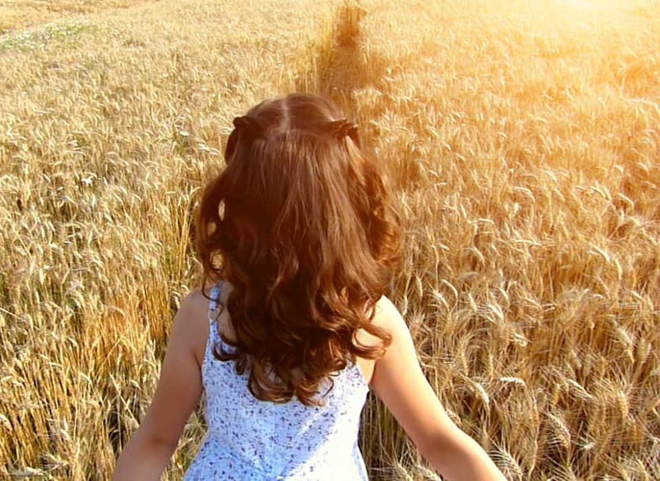 Small girl walking in fields
